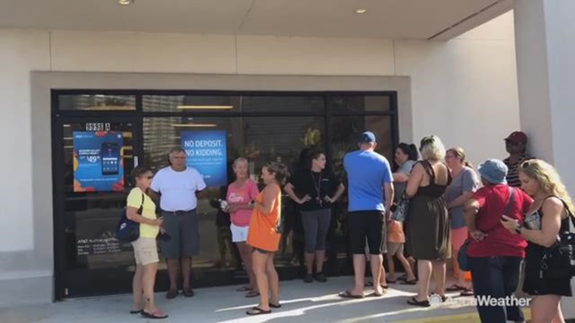 Verizon customers wait in line at an AT&T store in Panama City Beach, Florida to try and switch service so they can contact family and take care of business. 