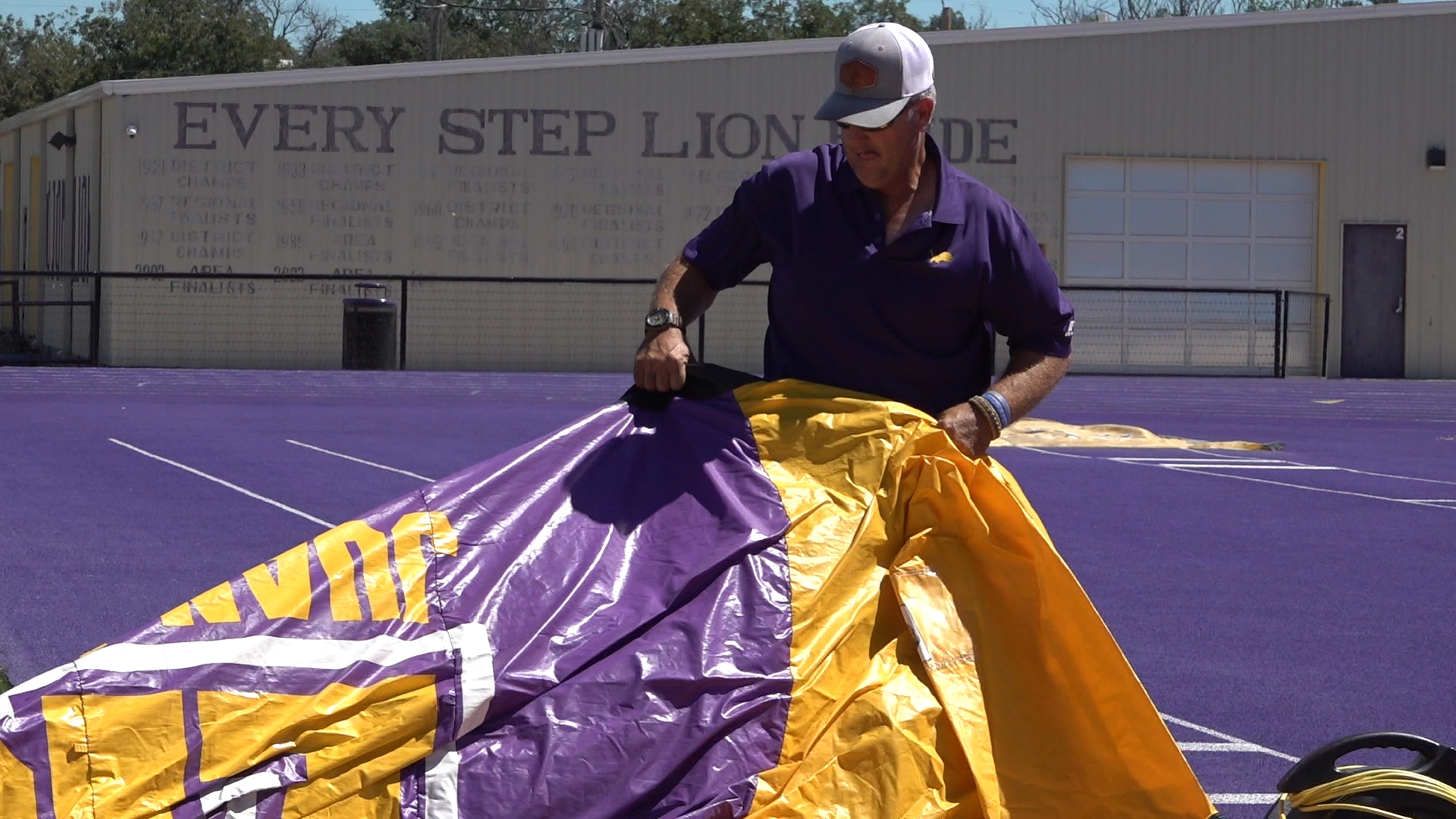 Mike Mitchell, an Ozona super fan, hauls the inflatable tunnel to each Lions game. Victoria Treto has a son on the varsity team.